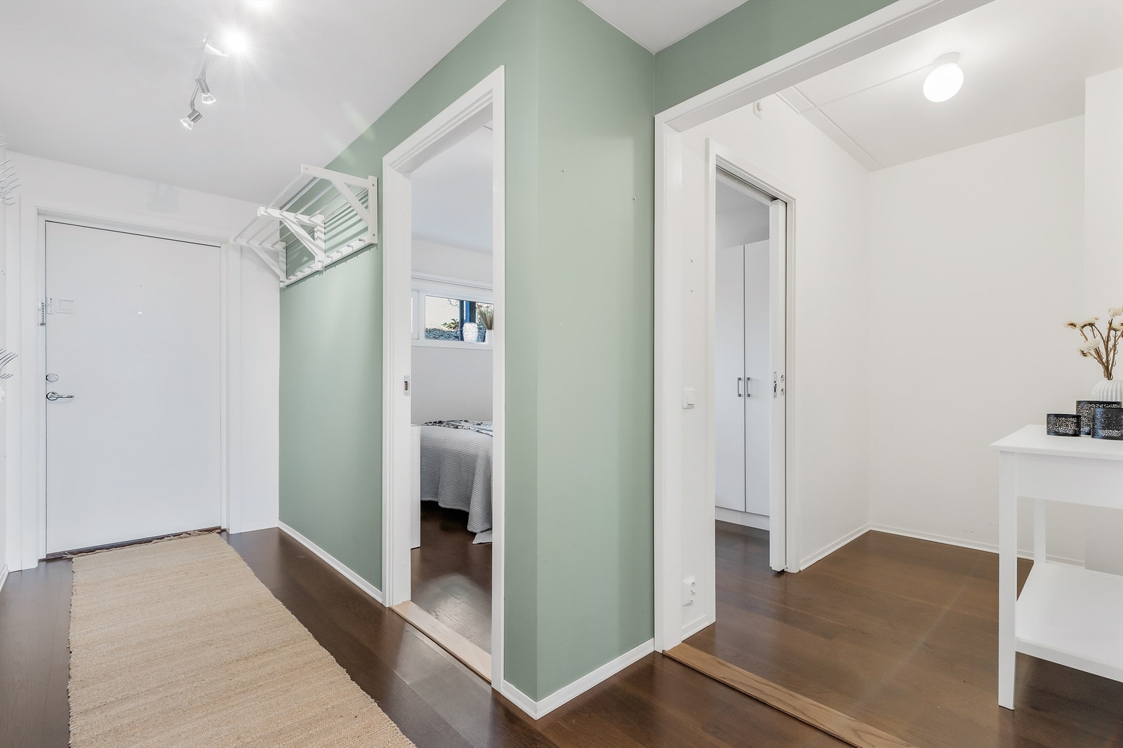 Lys og luftig gang med plass til knaggrekker og kommode for oppbevaring av ytterklær og sko. Fra gangen er det tilgang til 2 soverom, bad, WC og stuen. Galleribilde