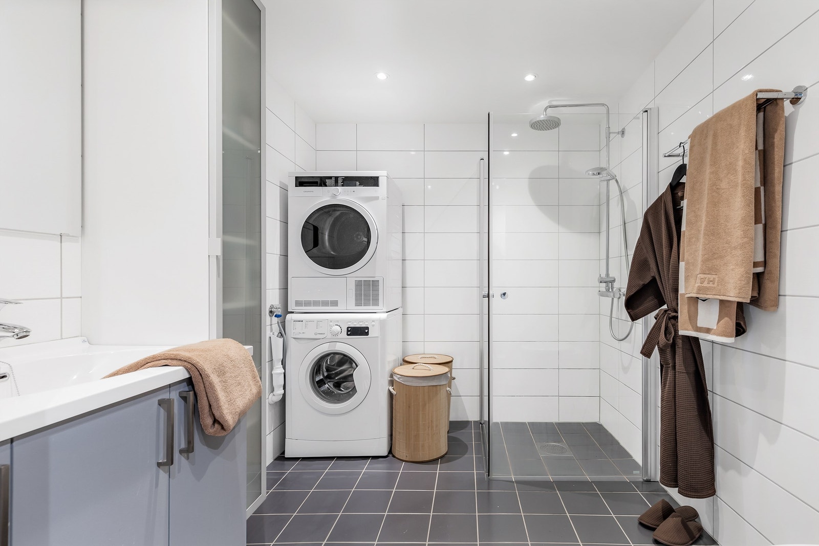 Bad fra byggeår. Flislagt gulv med varme og flislagte vegger. Nedsenket himling med downlights. Dusjarmatur tilkoblet hånddusj og regndusj. Opplegg for vaskemaskin. Galleribilde