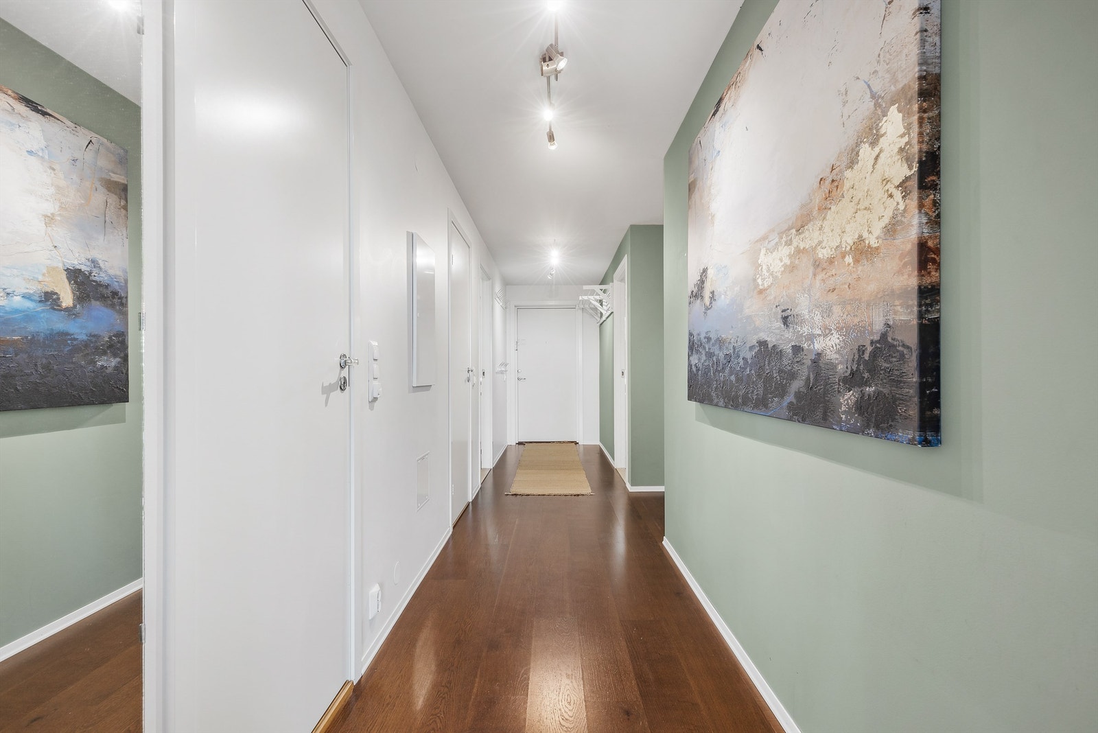 Lys og luftig gang med plass til knaggrekker og kommode for oppbevaring av ytterklær og sko. Fra gangen er det tilgang til 2 soverom, bad, WC og stuen. Galleribilde