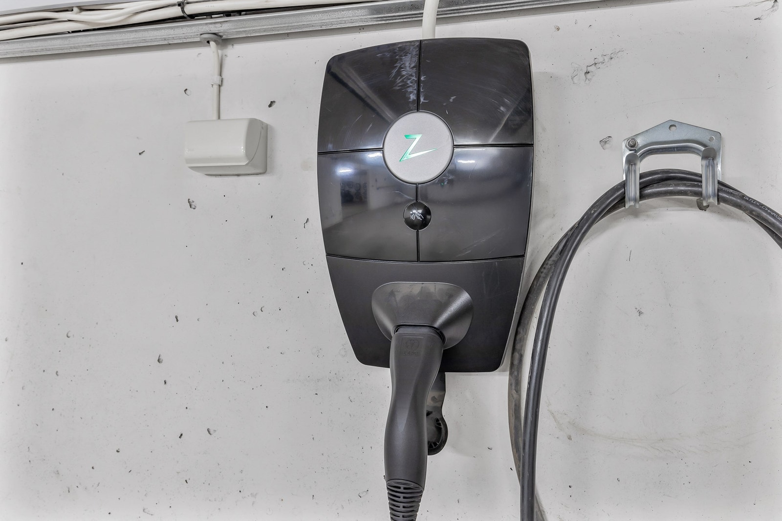 Det er montert lader for el-bil på den ene parkeringsplassen. Galleribilde