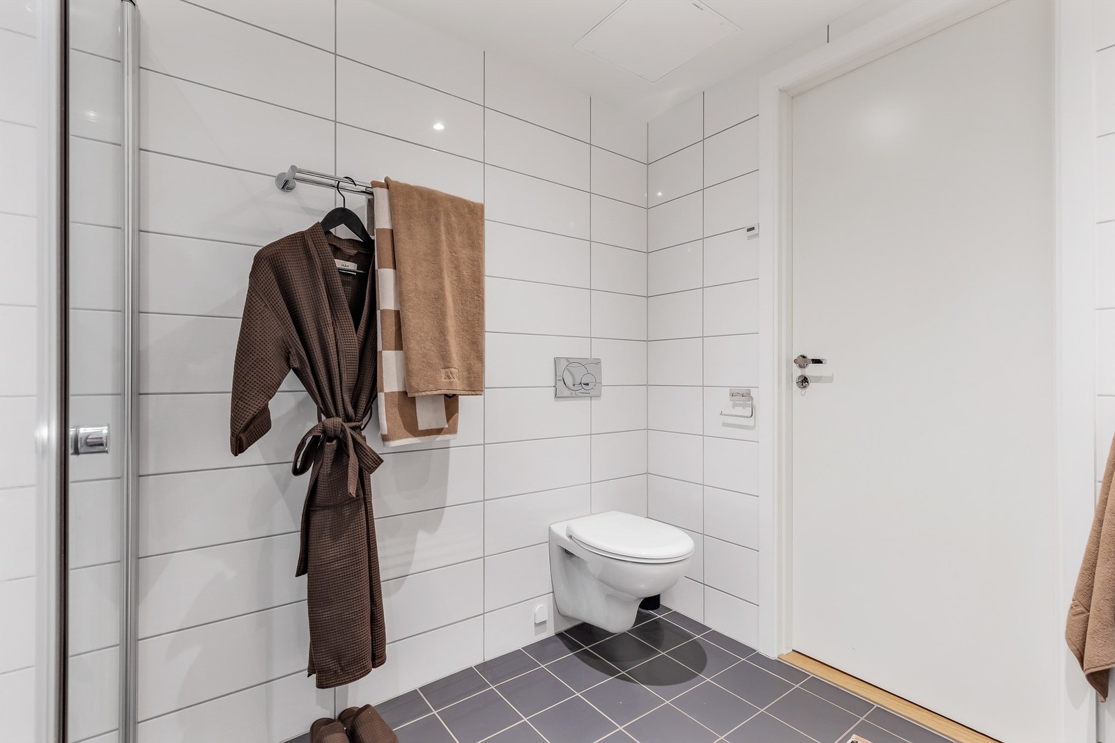 Vegghengt toalett. Nedsenket dusjhjørne med innfellbare glassdører. Galleribilde