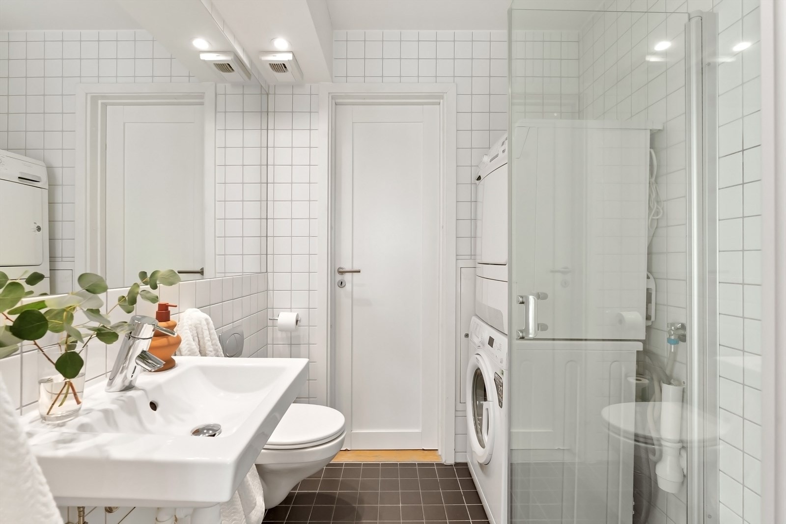 Delikat bad med dusj, servant, speil og wc. Opplegg for vaskemaskin og tørketrommel. Galleribilde