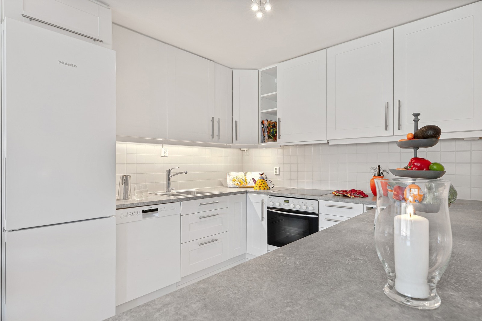 Integrerte hvitevarer som stekeovn og koketopp, mens oppvaskmaskin og kjøleskap/fryser står løst plassert i nisjer. Galleribilde