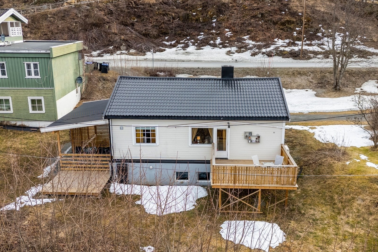 Fasade som viser terrasse fra 1.etasje og platting tilhørende utleiedel i kjeller Galleribilde