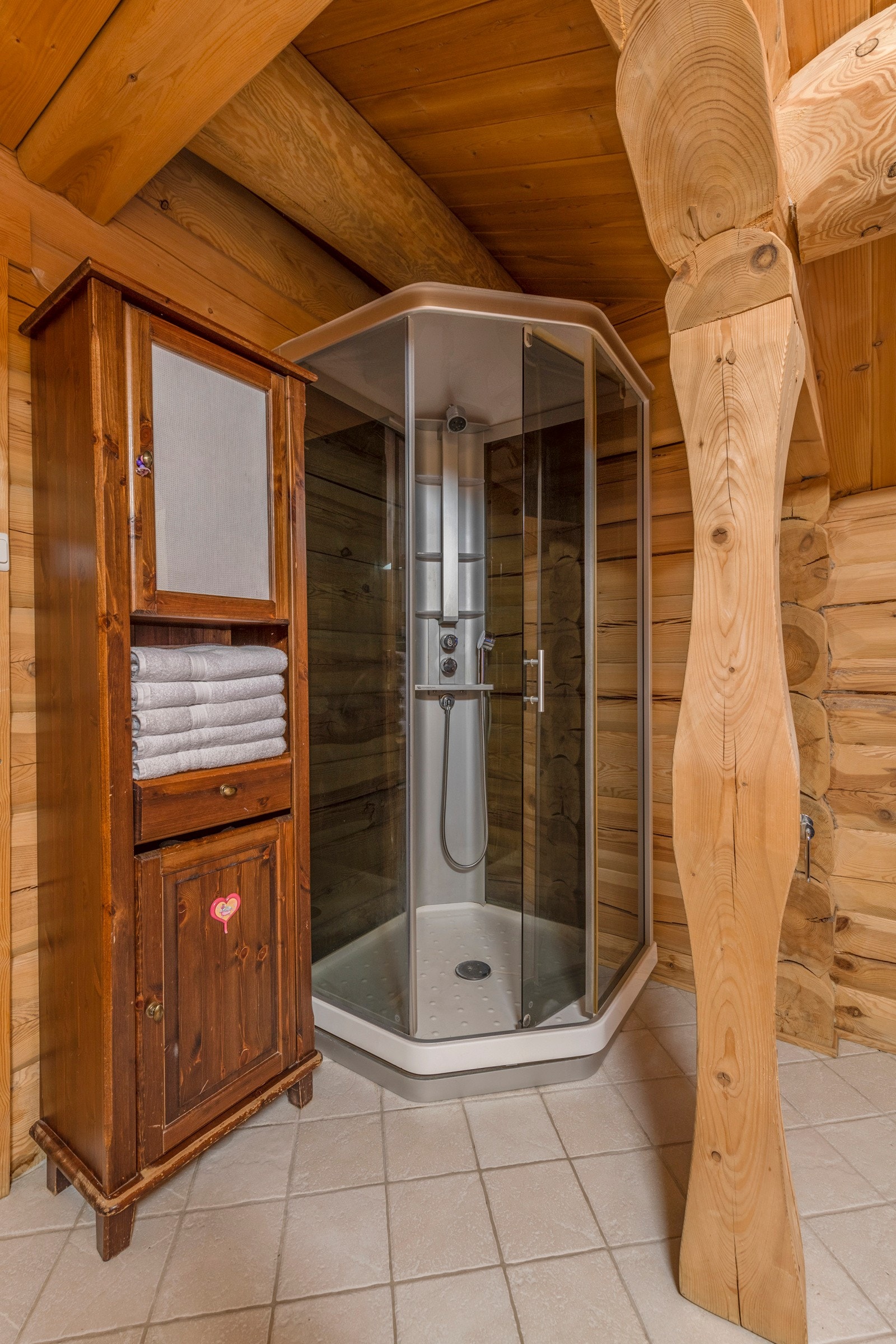 Baderom fra byggeår med fliser på gulv og vegger av tømmer. Galleribilde