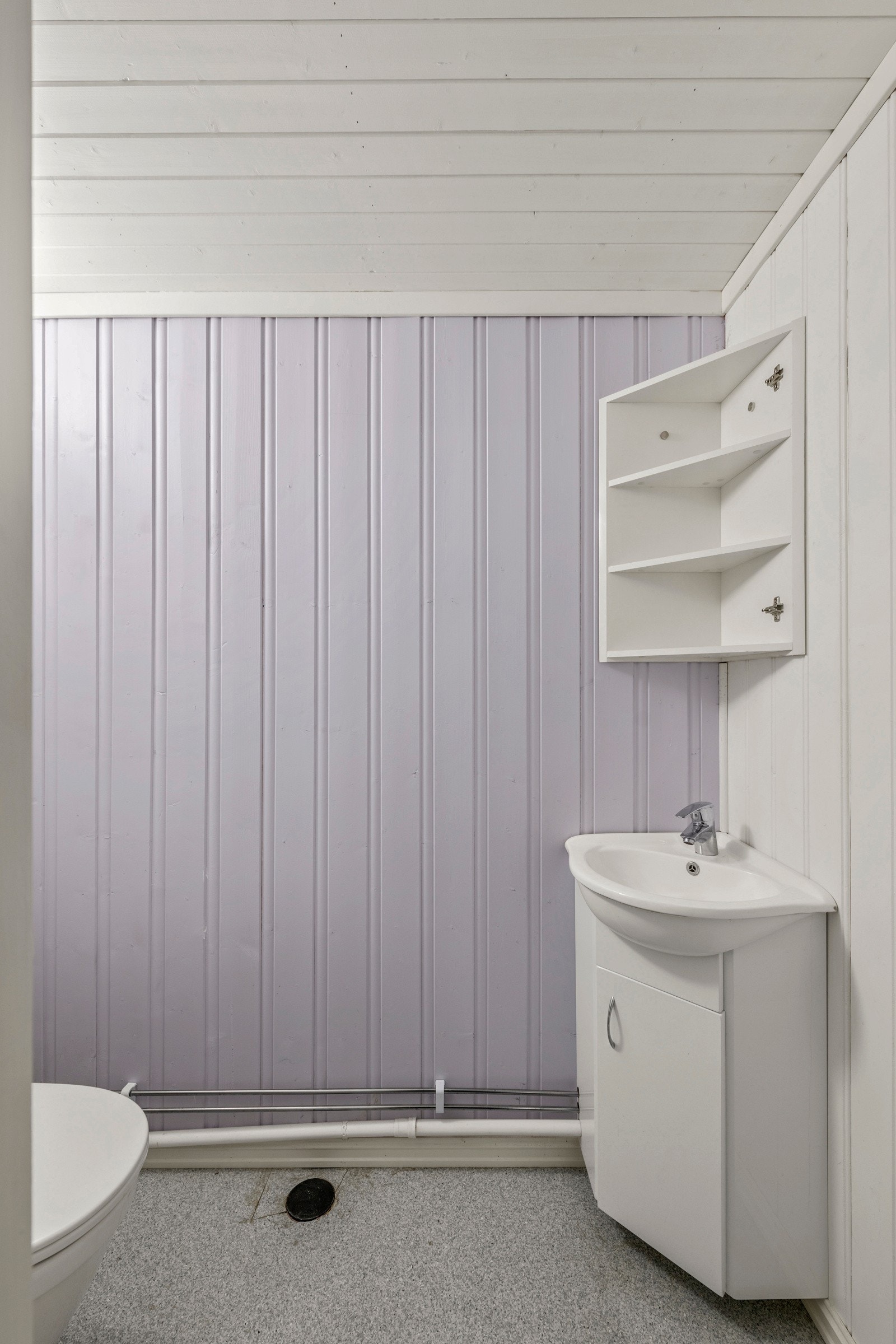 Praktisk toalettrom med gulvstående toalett og servant med underskap. Galleribilde