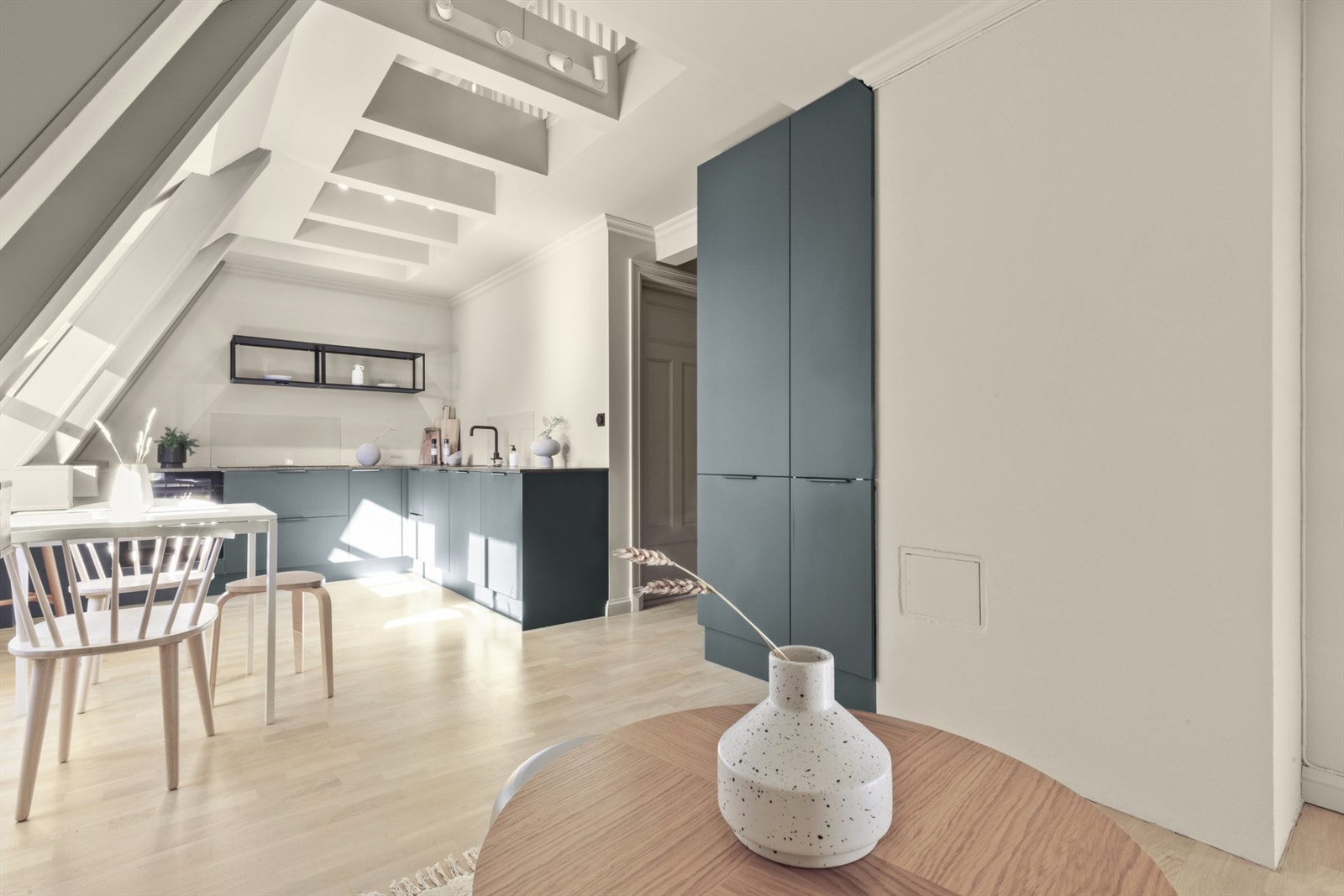 Stilfulle detaljer i farger og belysning i bjelkene i taket som både gir lys til oppholdsrommet og hemsen Galleribilde