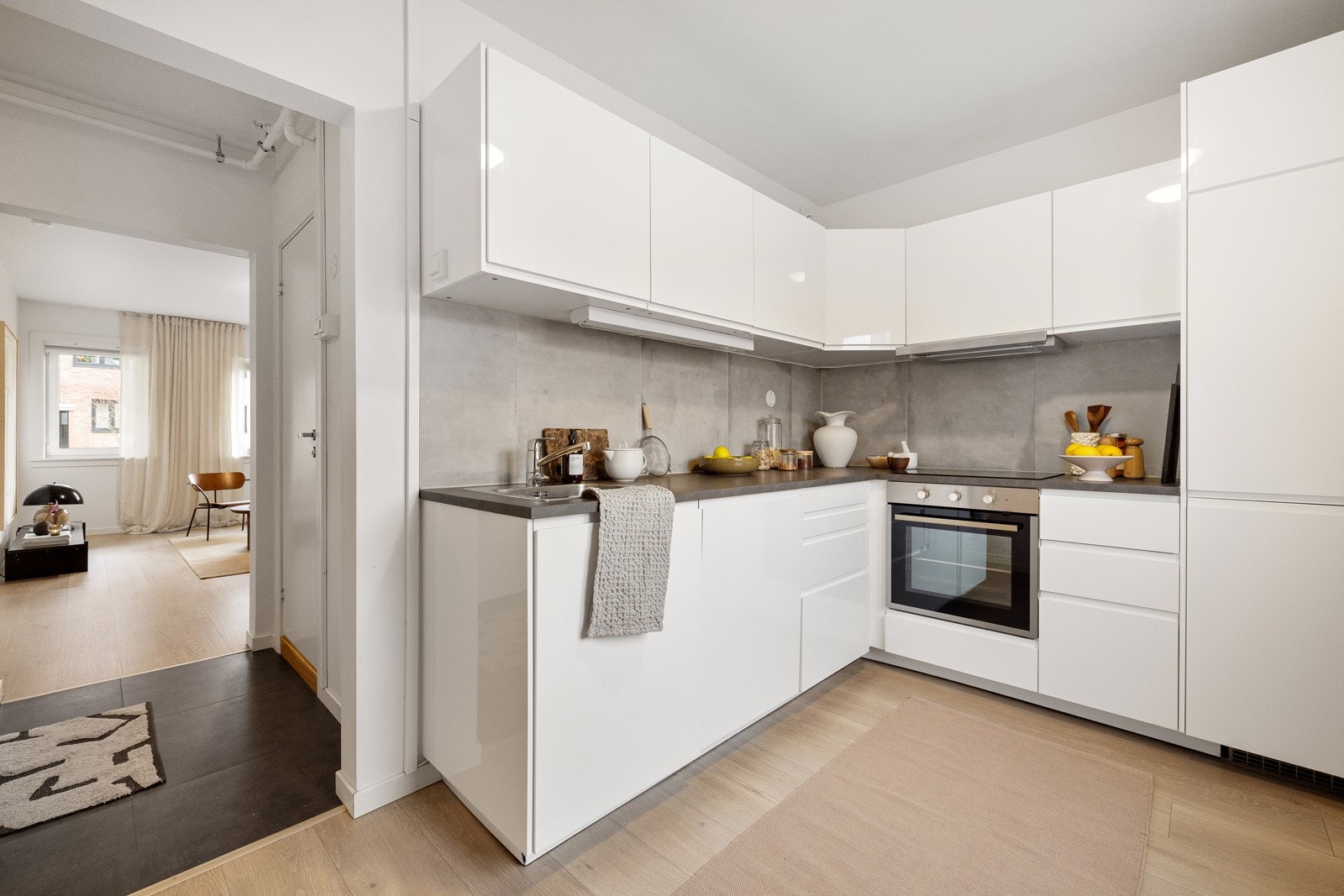 Tidsriktig glatt innredning fra IKEA med soft close, fliser over benk, armatur og laminat benkeplate med nedfelt stålkum. Galleribilde