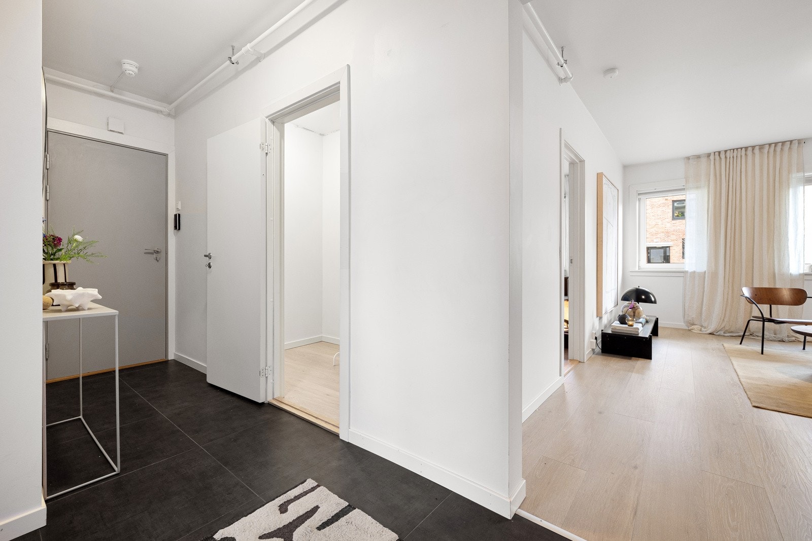 Romslig entré som gir et godt første inntrykk av leiligheten og har dørcalling system som gjør det enkelt å ta i mot gjester. Galleribilde