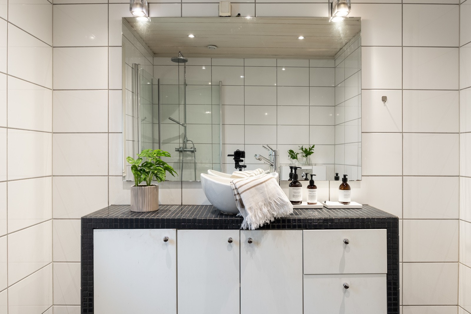 Badet er innredet med vegghengt servantinnredning med heldekkende servant og ett-greps armatur, samt speil på vegg over servant. Galleribilde