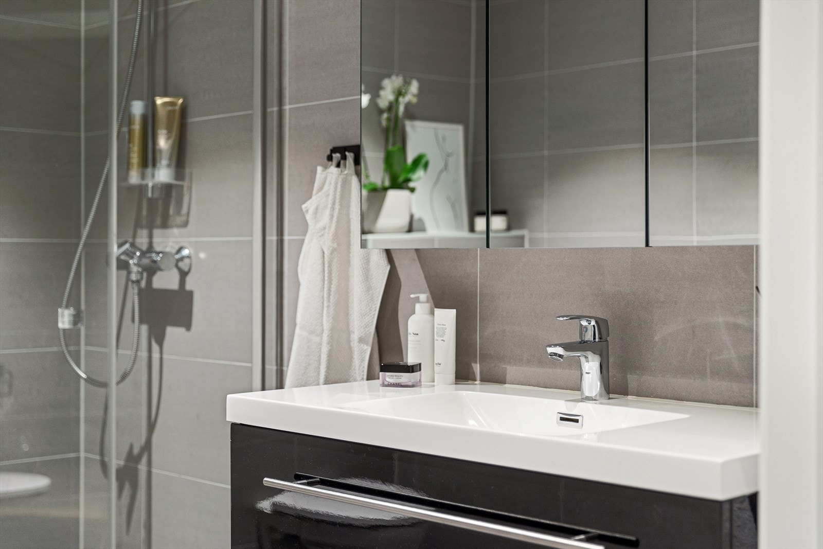 Vegghengt servantskap med speil og ovenpåliggende servant i porselen med ett-greps armatur. Galleribilde