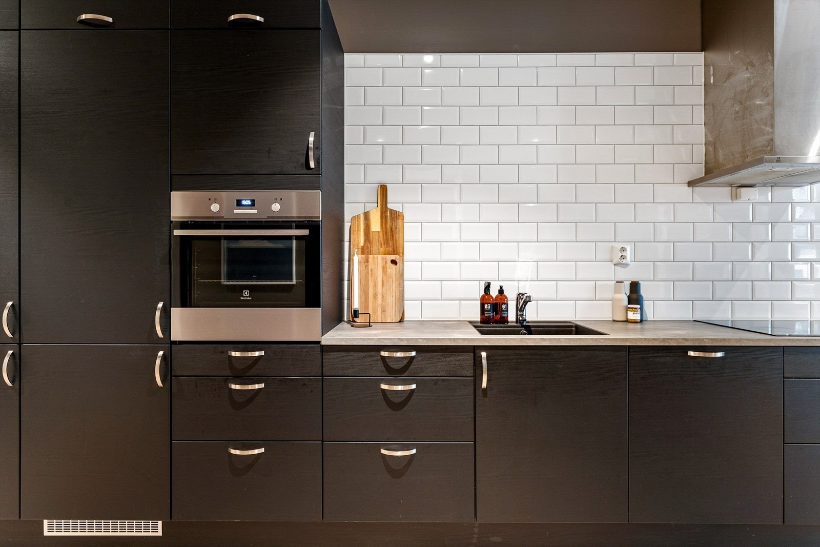 Videre er det flislagt over kjøkkenbenk, og oppvaskkummen er nedsenket i kompositt med ett-greps armatur. Galleribilde