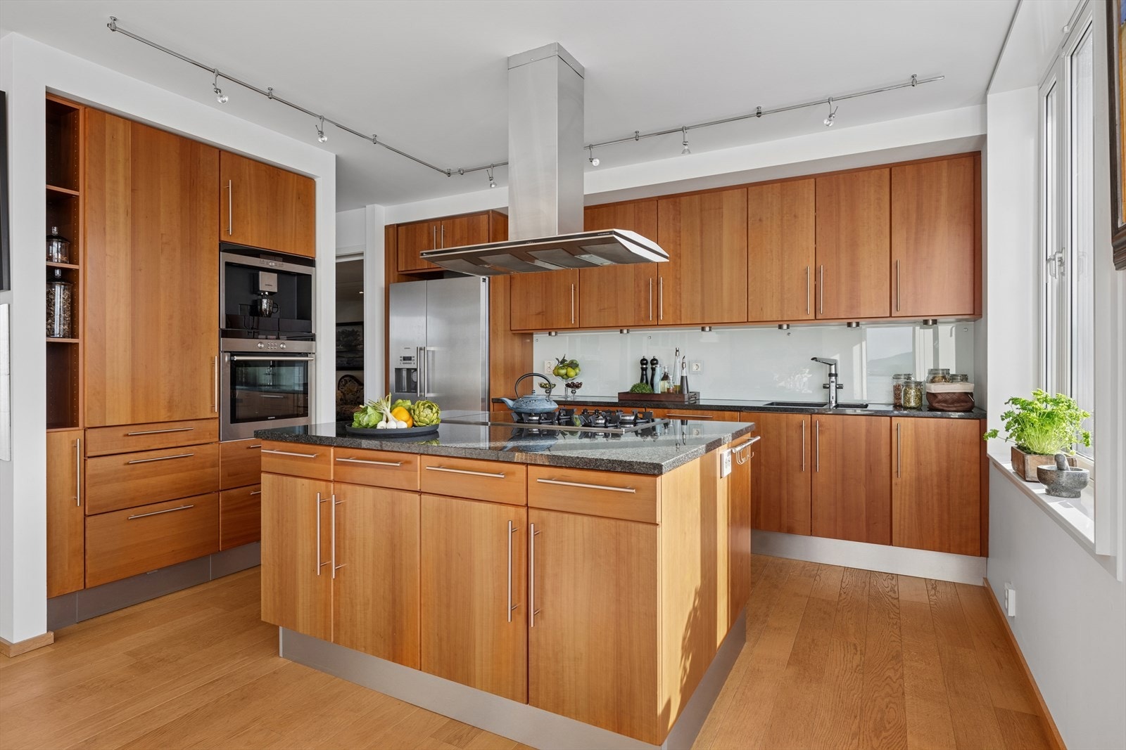 Innredningen har glatte fronter, stein benkeplate og belysning under overskap. Galleribilde