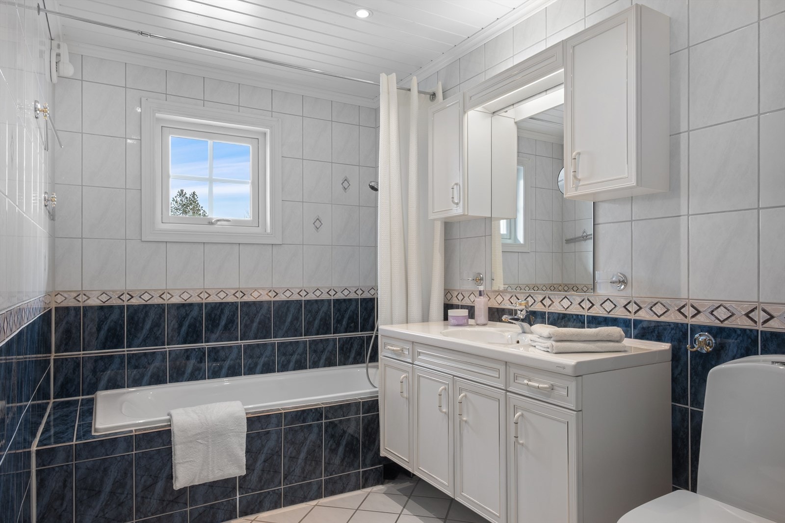 Badet i 1. etasje har flislagte overflater, varmekabler, downlights og avtrekksvifte. Rommet har badekar med dusjfunksjon til glede for liten og stor. Galleribilde