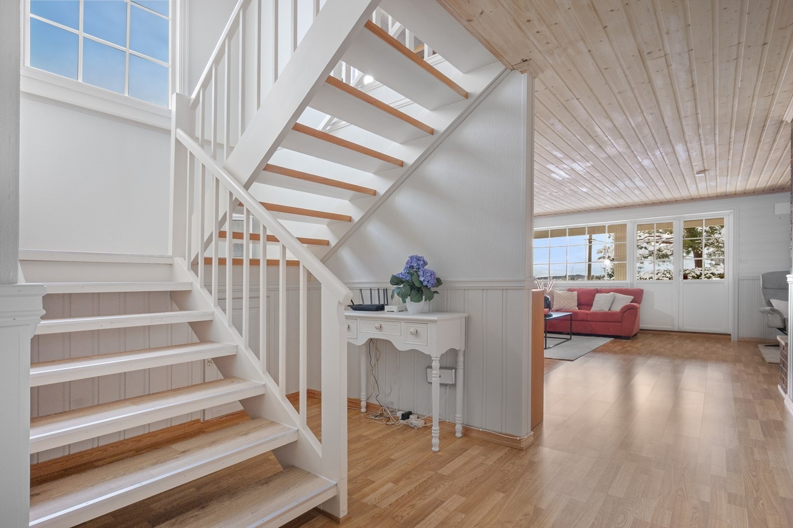Fra 1. etasje fører åpen trapp ned til boligens underetasje. I trappenedgangen er et stort vindu for naturlig lys og utsyn. Galleribilde