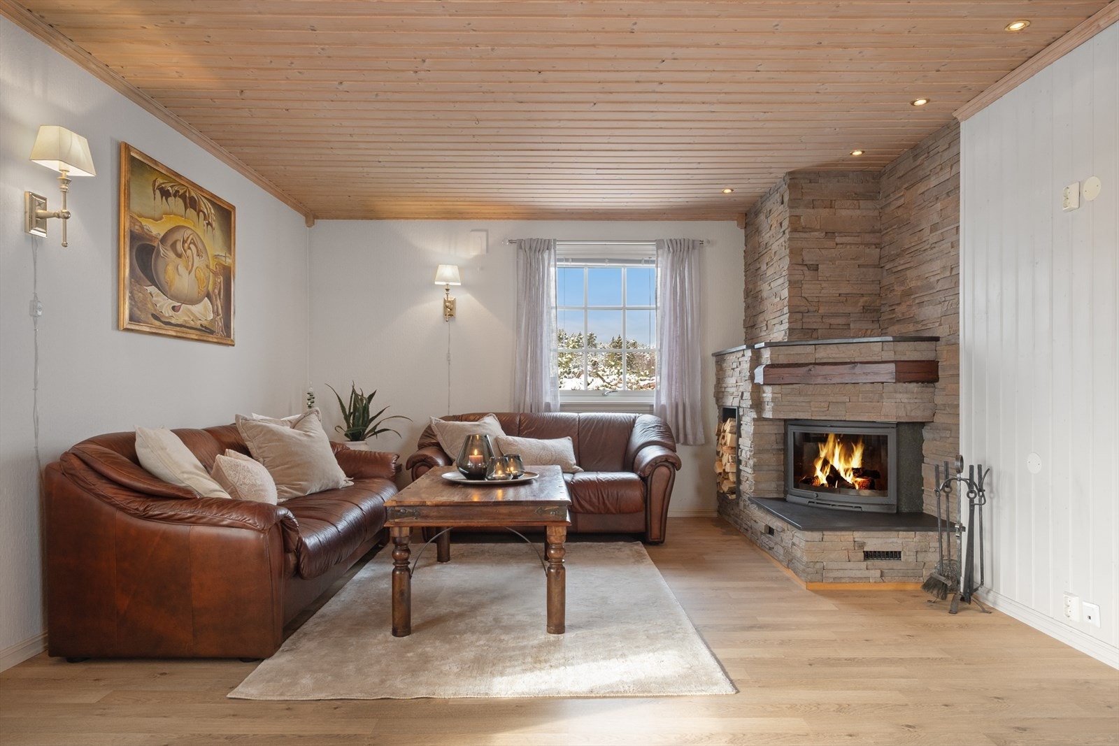 I hjørnet ved dagens sofaløsning er en steinbekledd peis for varme og hygge med vedhylle og downlights. Galleribilde