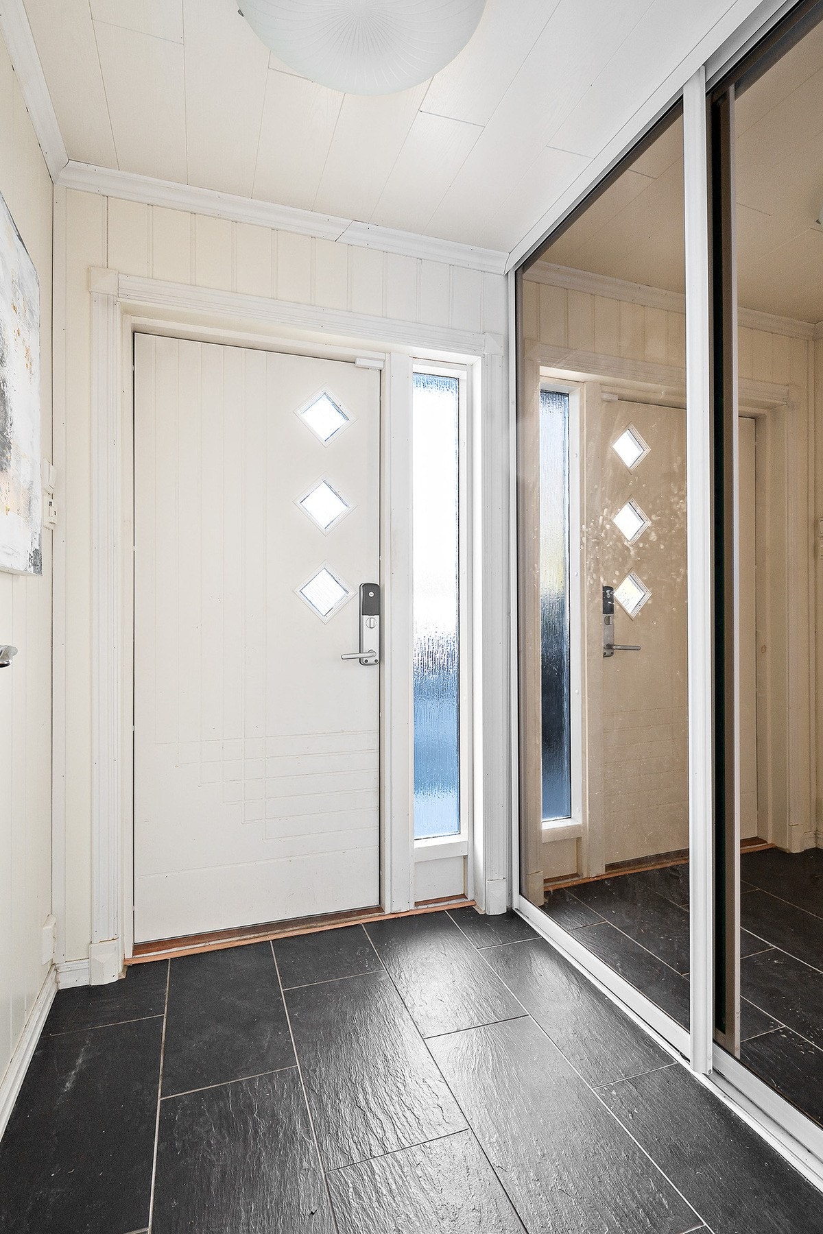 Lys og innbydende entré med gode oppbevaringsmuligheter i skyvedørsgarderobe Galleribilde