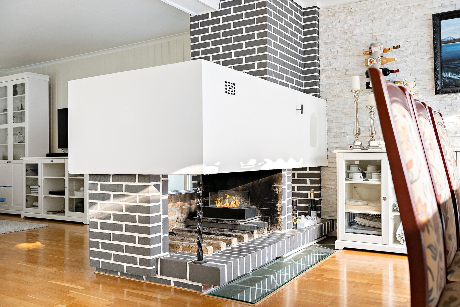 En naturlig romskiller er denne flotte peisen som sørger for godt med varme på vinterhalvåret Galleribilde