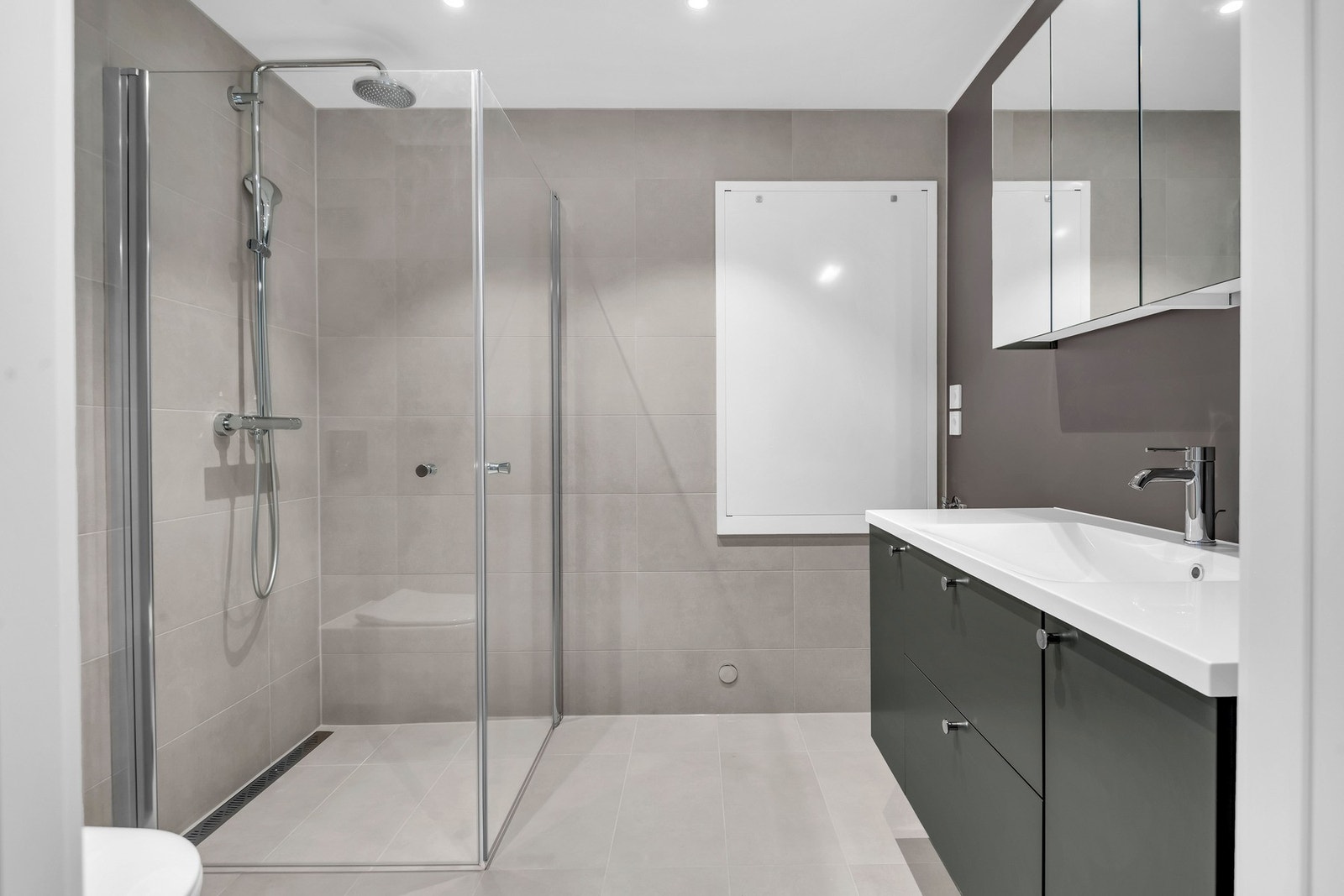 Badet leveres med stilren moderne innredning fra Sigdal, og er utstyrt med takspotter som gir et behagelig lys. I tillegg har de elektriske varmekabler i gulvet. Galleribilde