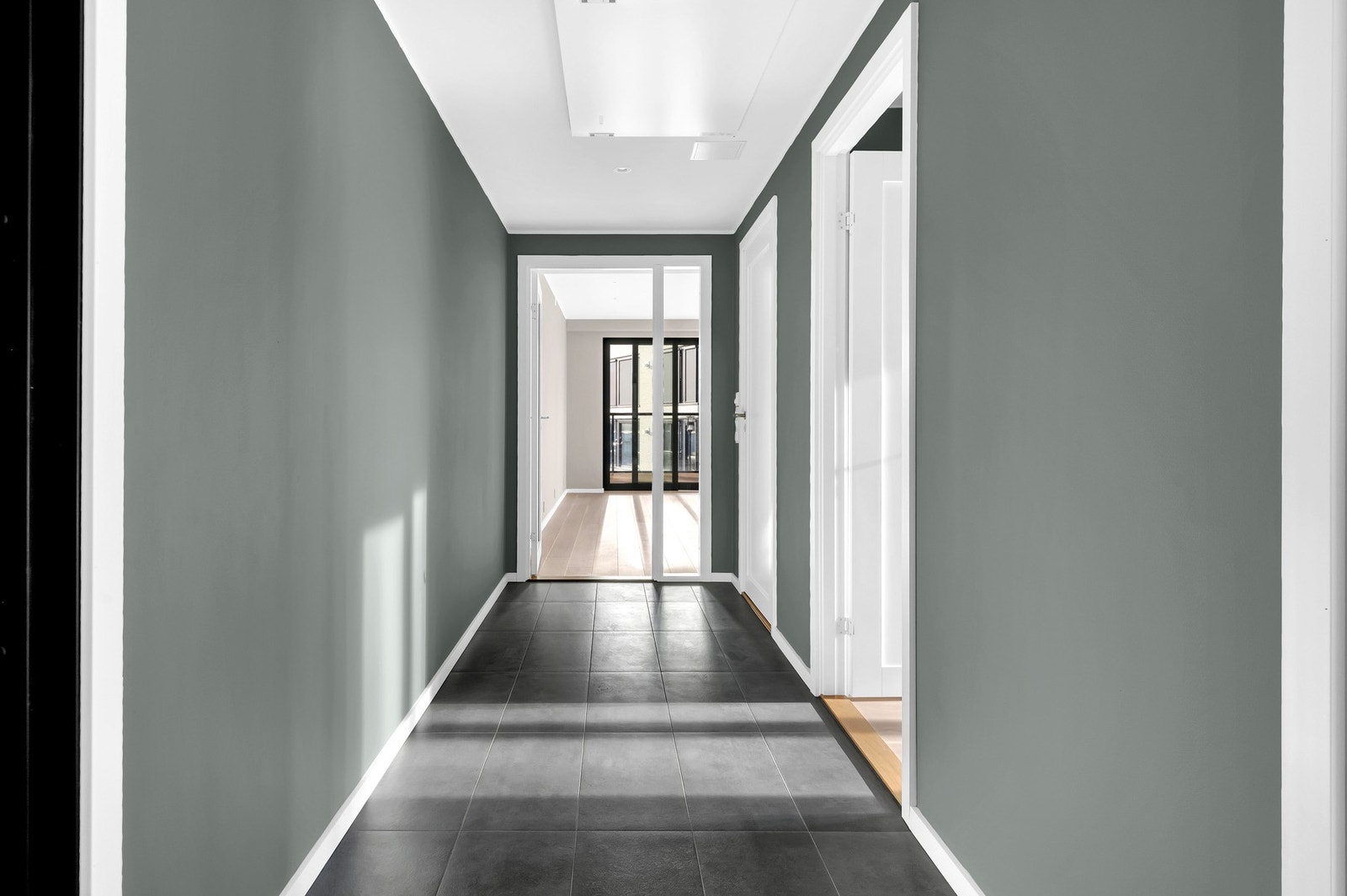 En glassdør i hallen bidrar til å fordele lyset videre inn i leiligheten, noe som skaper en lys og luftig atmosfære. Galleribilde