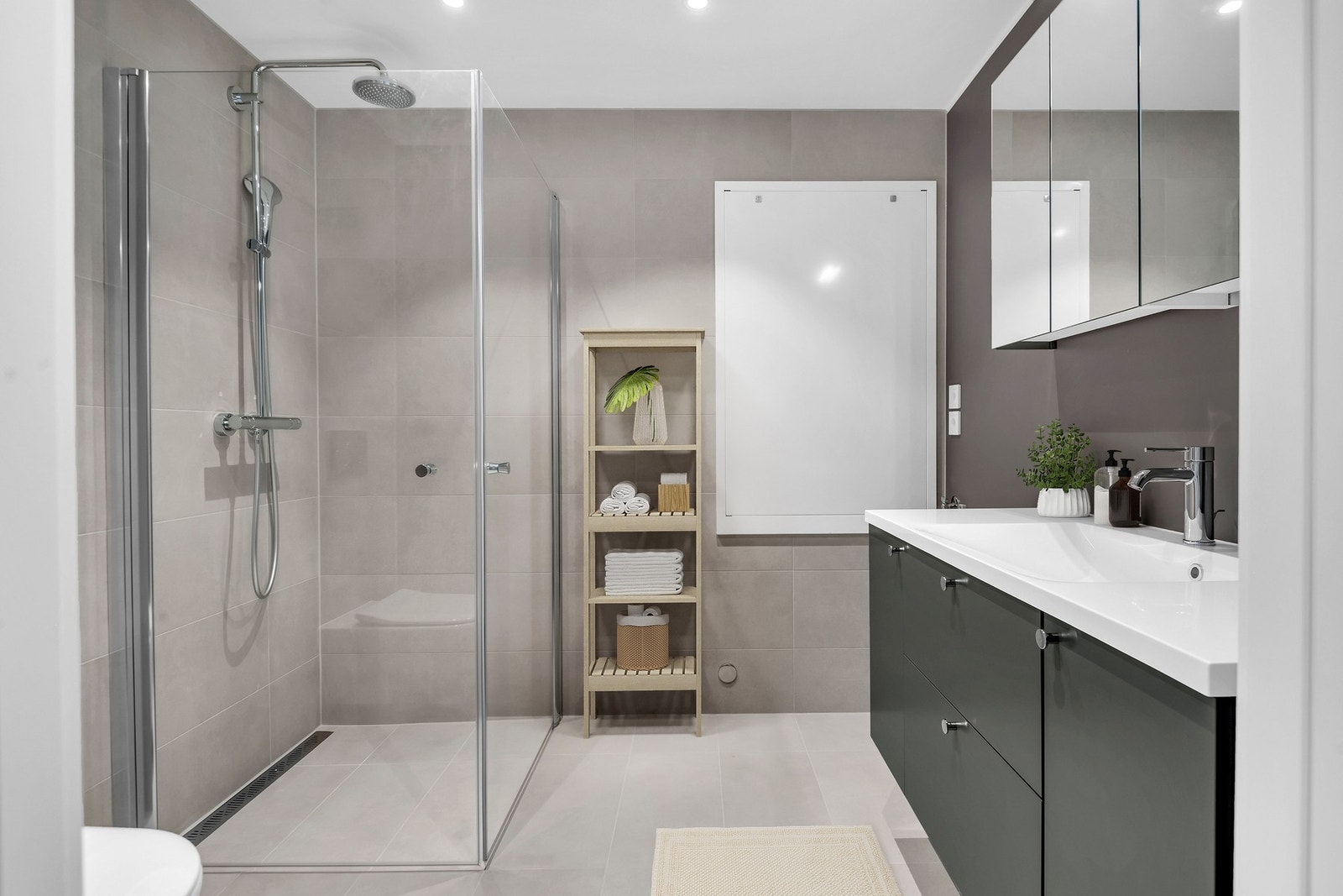 Det moderne badet er smakfullt innredet og inkluderer praktiske fasiliteter som opplegg for vaskemaskin/kondenstørketrommel. Galleribilde