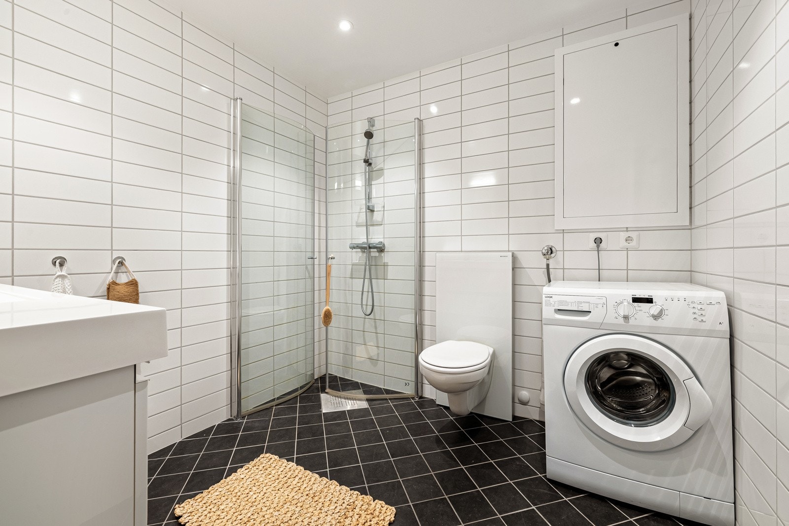 Badet er helfliset med innfelte downlight i tak og gulvvarme. Det er opplegg for vaskemaskin og tørketrommel. Galleribilde