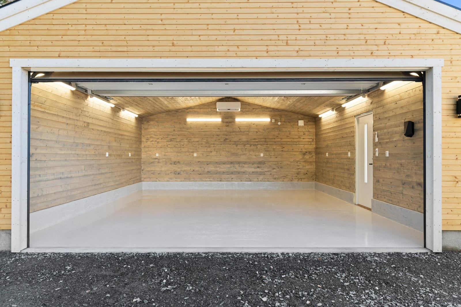 Dobbelgarasjen er gjennomført med panel på veggene og det er installert varmepumpe. Galleribilde