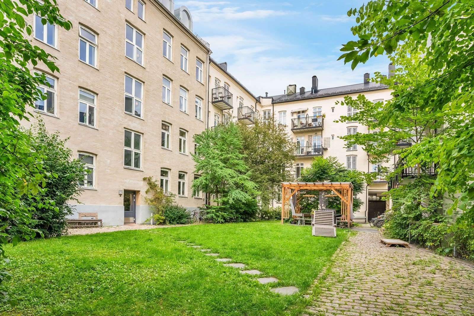 Pent opparbeidet fellesområde med grøntområder, sittegrupper og felles sykkelparkering. Galleribilde