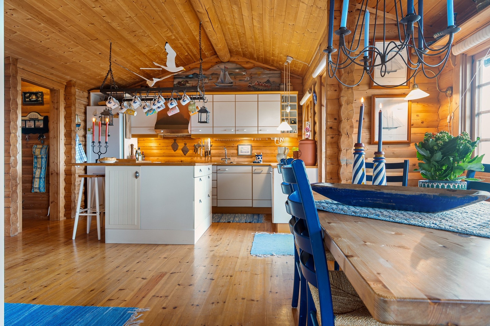 Lys og luftig kjøkkeninnredning med kjøkkenøy som binder stuen og kjøkkenet Galleribilde