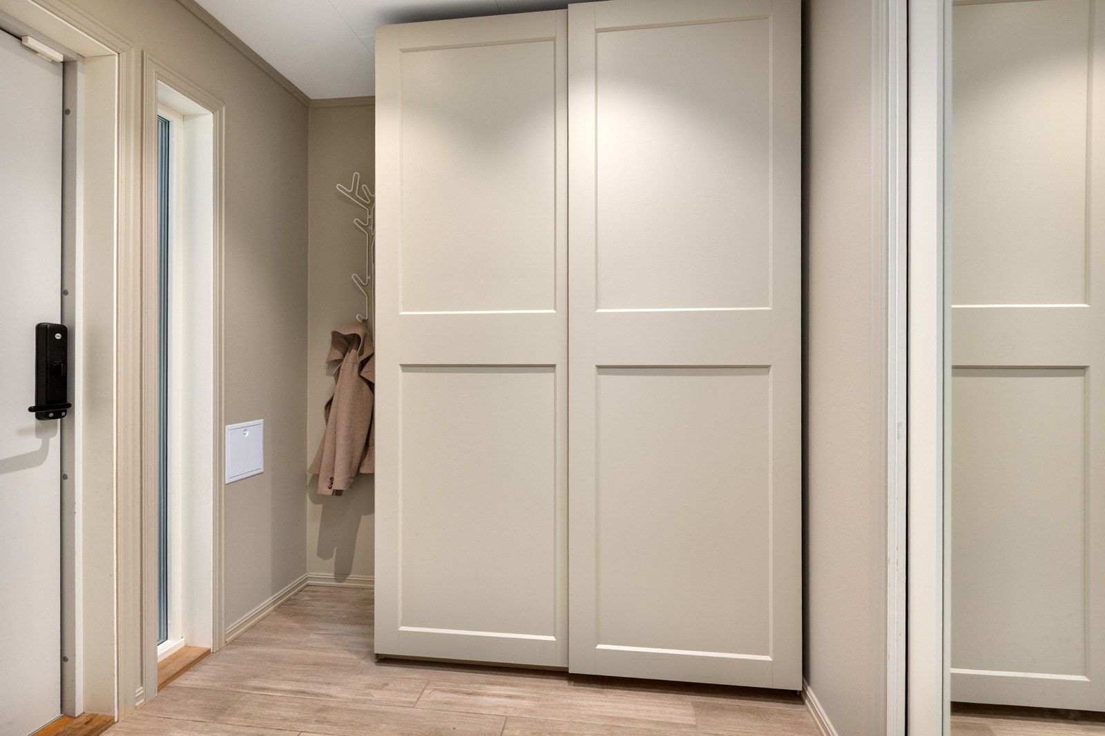 Velkommen inn! Her er det godt med oppbevaringsplass i en takhøy skyvedørsgarderobe. Galleribilde