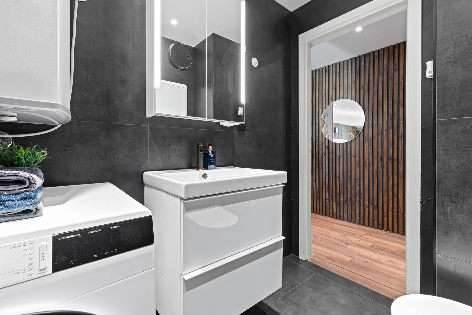 Her finner du et dusjhjørne med glassdører, vegghengt toalett og en servantseksjon med oppbevaring. Her har du opplegg for vaskemaskin som gjør hverdagen enklere. Galleribilde