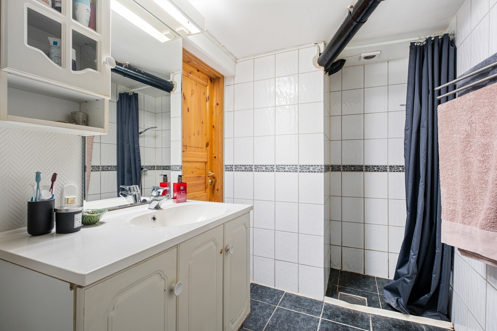 Badet er på 4,5m² med flislagt gulv og vegger, hvor deler av vegg er med malt glassfiberstrie. Badet byr på behagelig gulvvarme Galleribilde