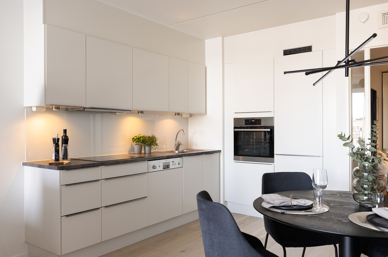 Kjøkkenet er funksjonelt og moderne med en praktisk glassoverflate over benken, som gir et stilrent uttrykk. Galleribilde