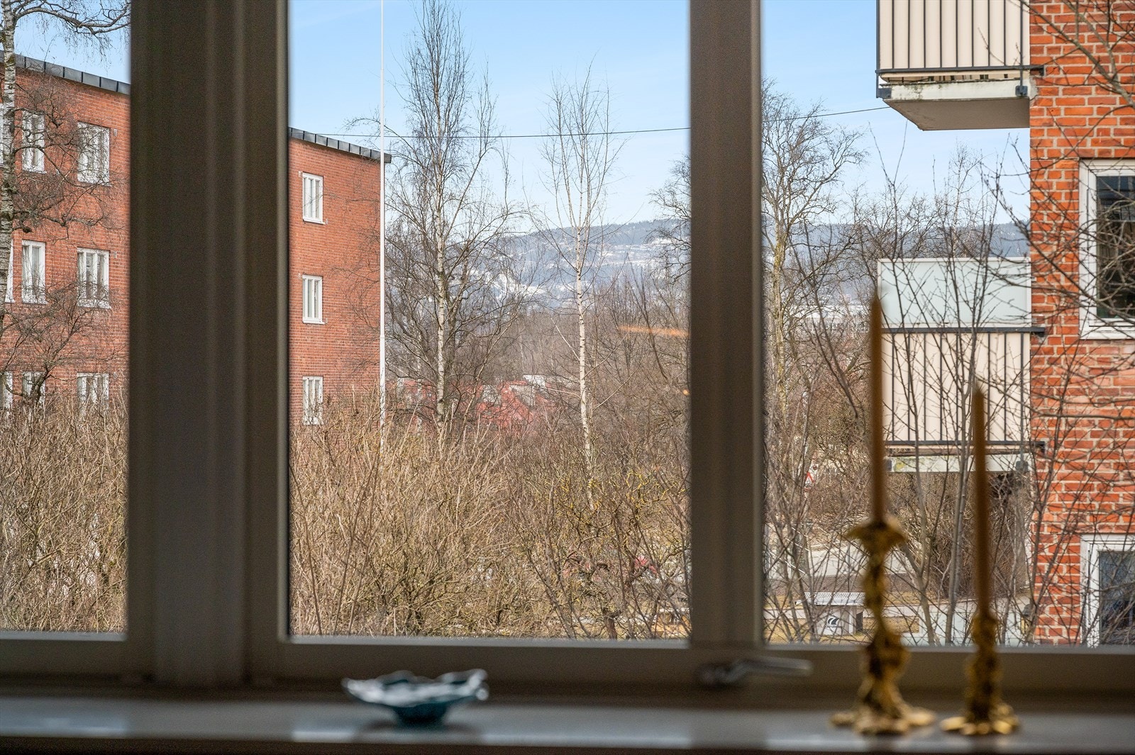 Utsyn fra stuevinduet. På sommerstid er det grønne omgivelser som omkranser leiligheten og blokkene. Galleribilde