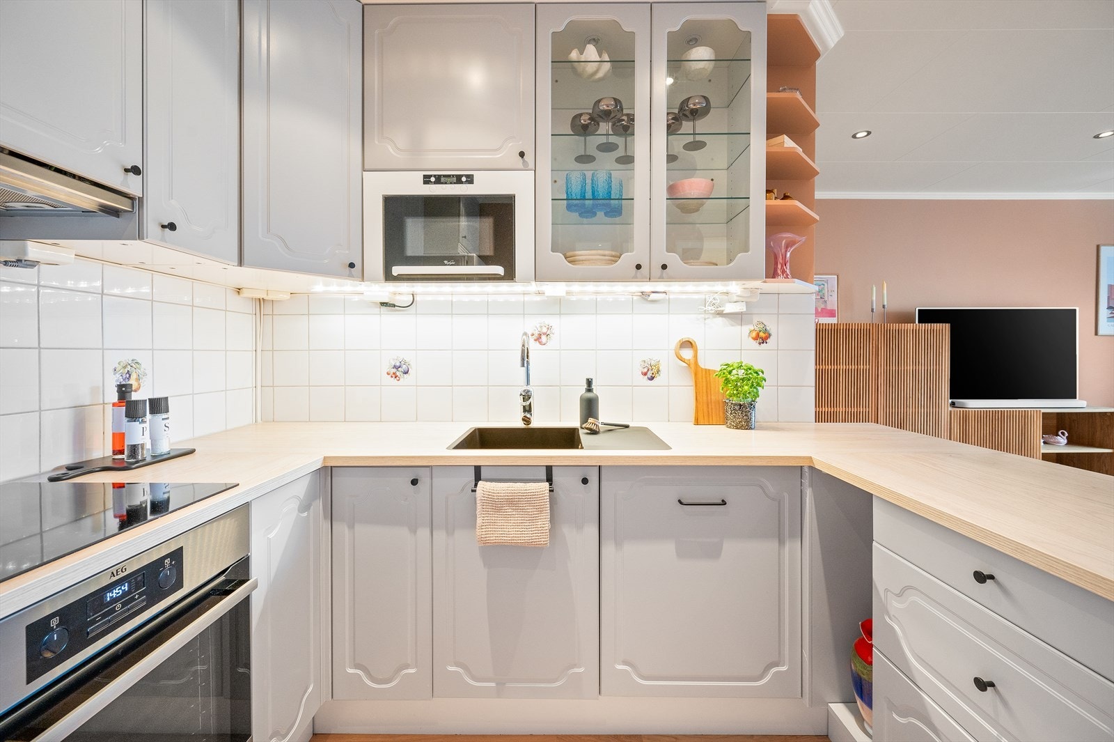 Kjøkkeninnredningen med profilerte fronter og laminat benkeplate i en etterligning av treverk. Galleribilde