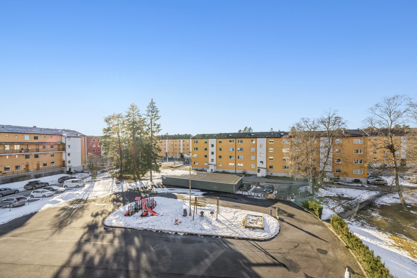 Utsikt fra balkong ned til lekeplass. Her lages det skøytebane om vinteren. Galleribilde