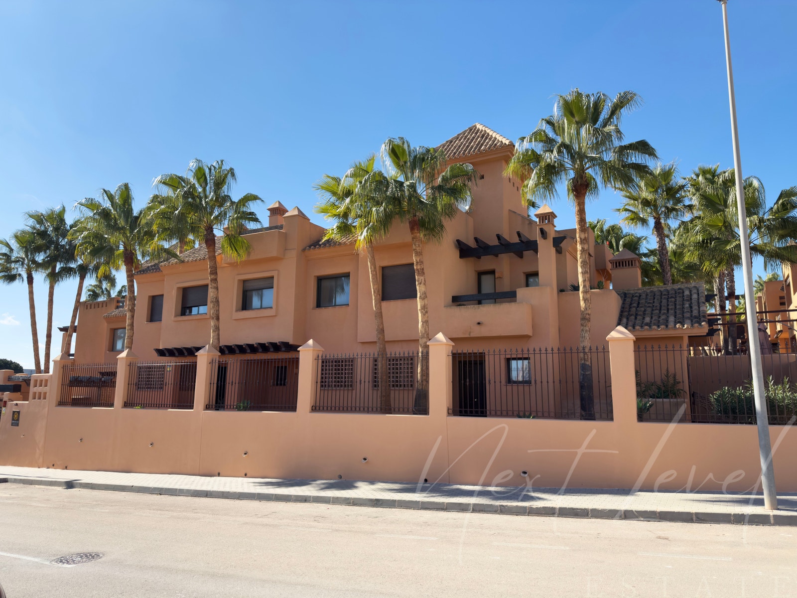 Fasade fra veien. Huset ligger på enden og er det som har "tårn" på deler av takterassen. Galleribilde