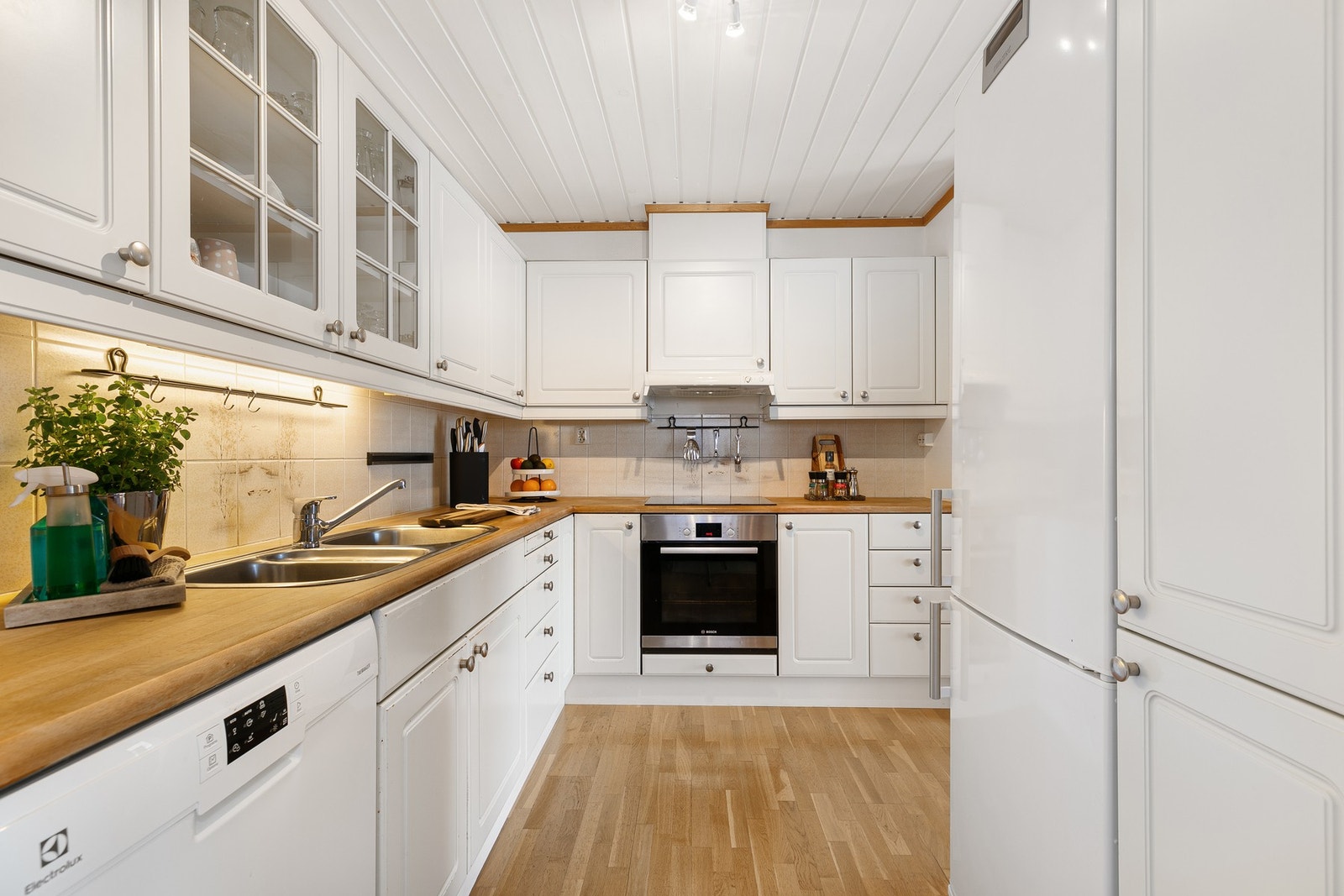 Innredning har profilerte fronter og benkeplater i behandlet tre med nedfelt kum av stål. Galleribilde