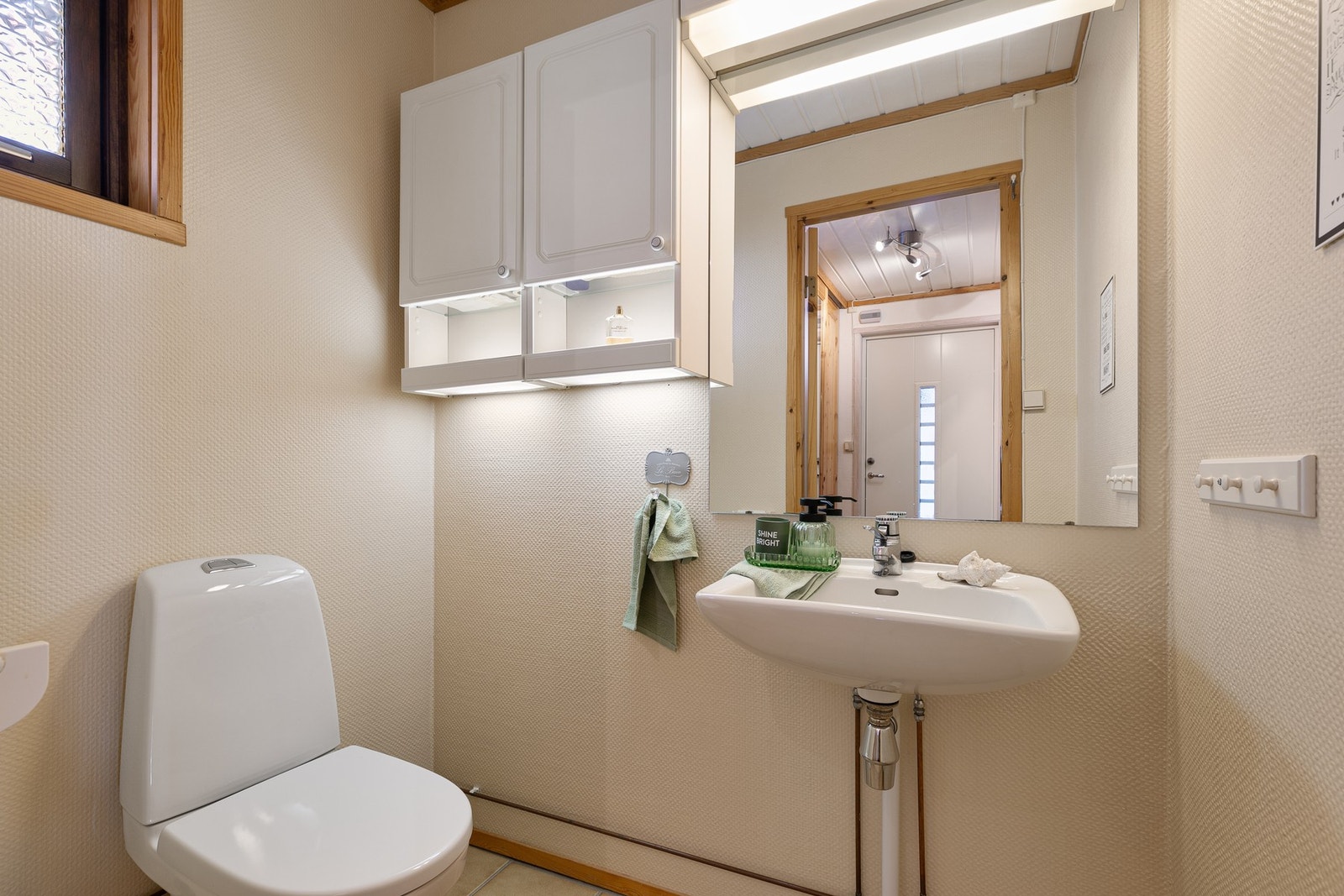 Med inngang fra entré ligger et toalettrom fra byggeår, med flislagt gulv Galleribilde