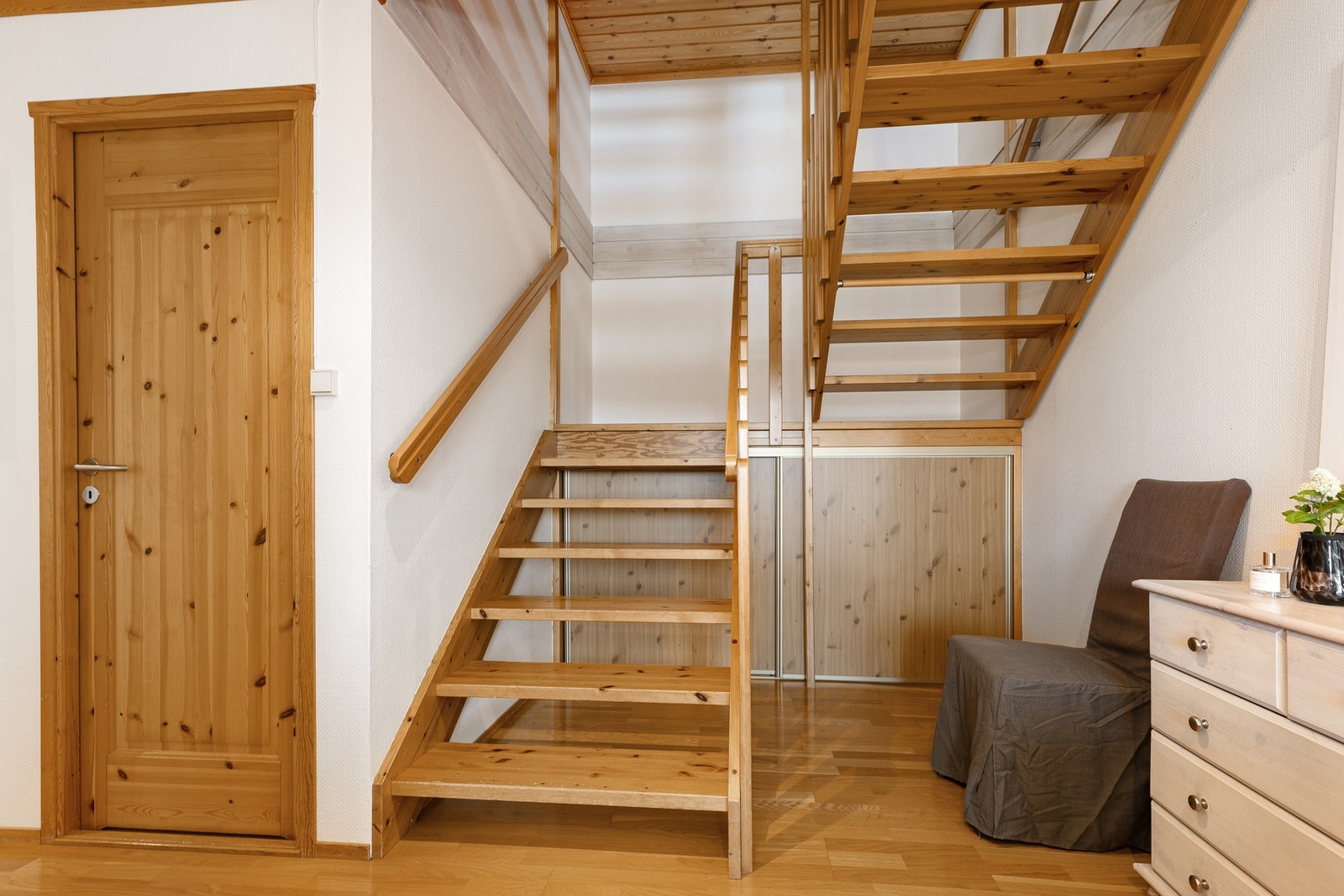 Plassen under trappeløpet i underetasjen er godt utnyttet med en lav skyvedørsgarderobe Galleribilde