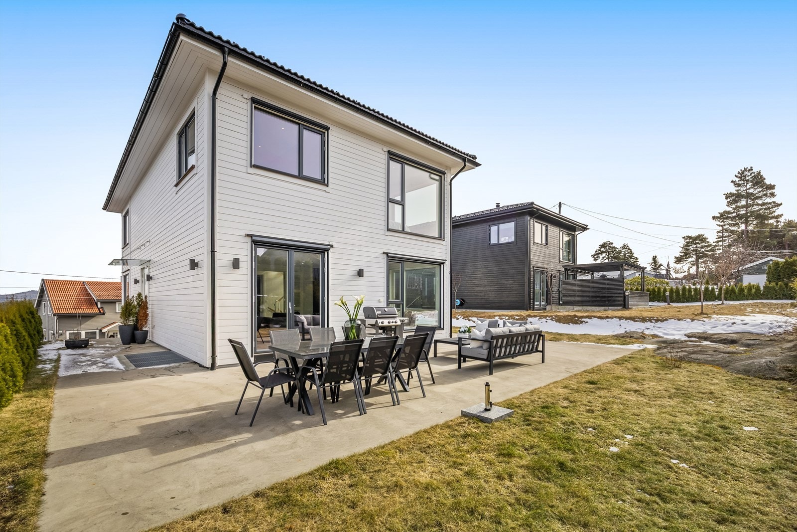 Den støpte markterrassen går fra hovedinngangen og rundt vestsiden av boligen. Galleribilde