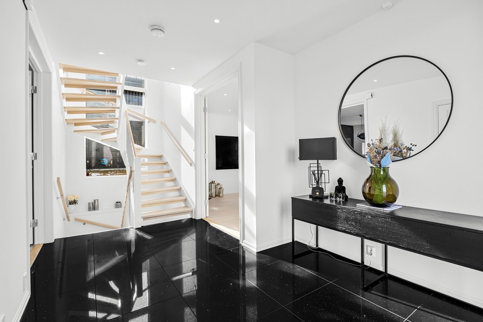 Innbydende hall/trapperom med flislagt gulv mellom stue og kjøkken. Galleribilde