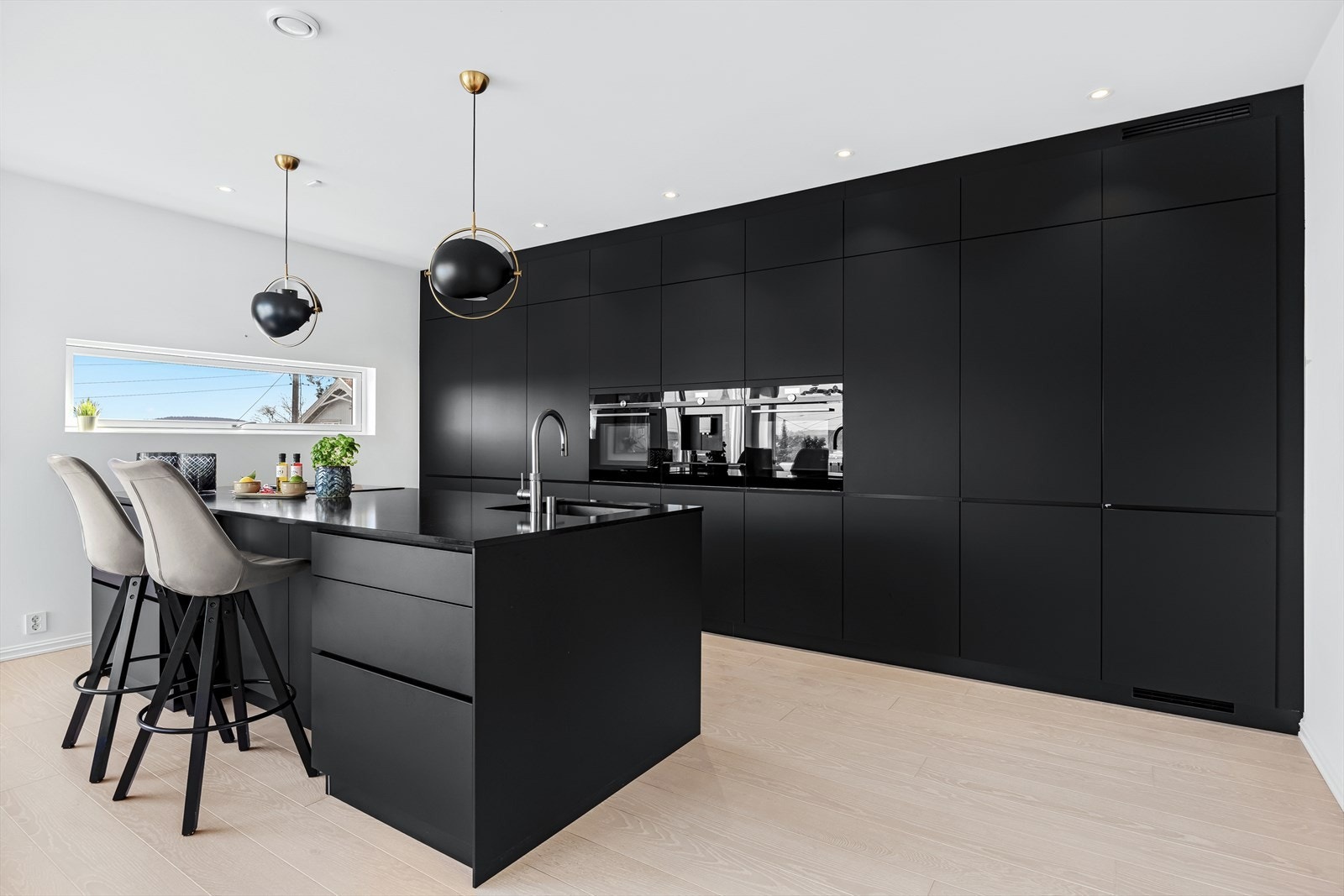 Stilren og moderne kjøkkeninnredning fra Kvik med integrerte hvitevarer fra Siemens og komposittstein benkeplate. Galleribilde