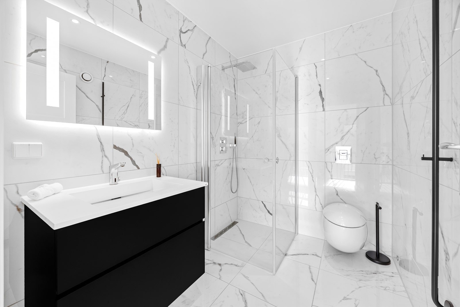 Delikat flislagt bad II med servant, dusjhjørne med glassdører og vegghengt wc med innebygget sisterne. Innebygget dusjarmatur fra Tapwell. Galleribilde