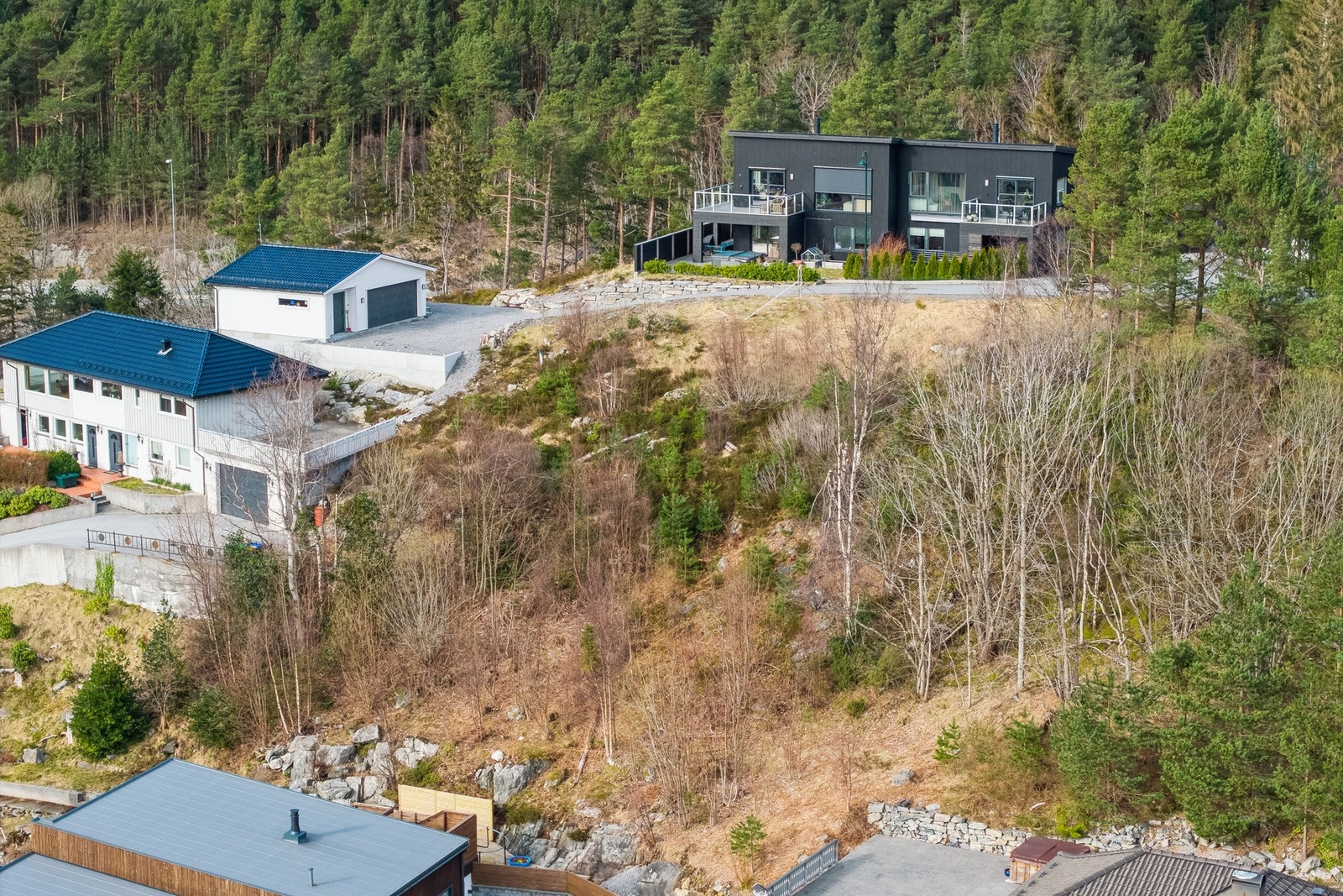 Tomten ligger høyt og fritt i skrått terreng. Galleribilde