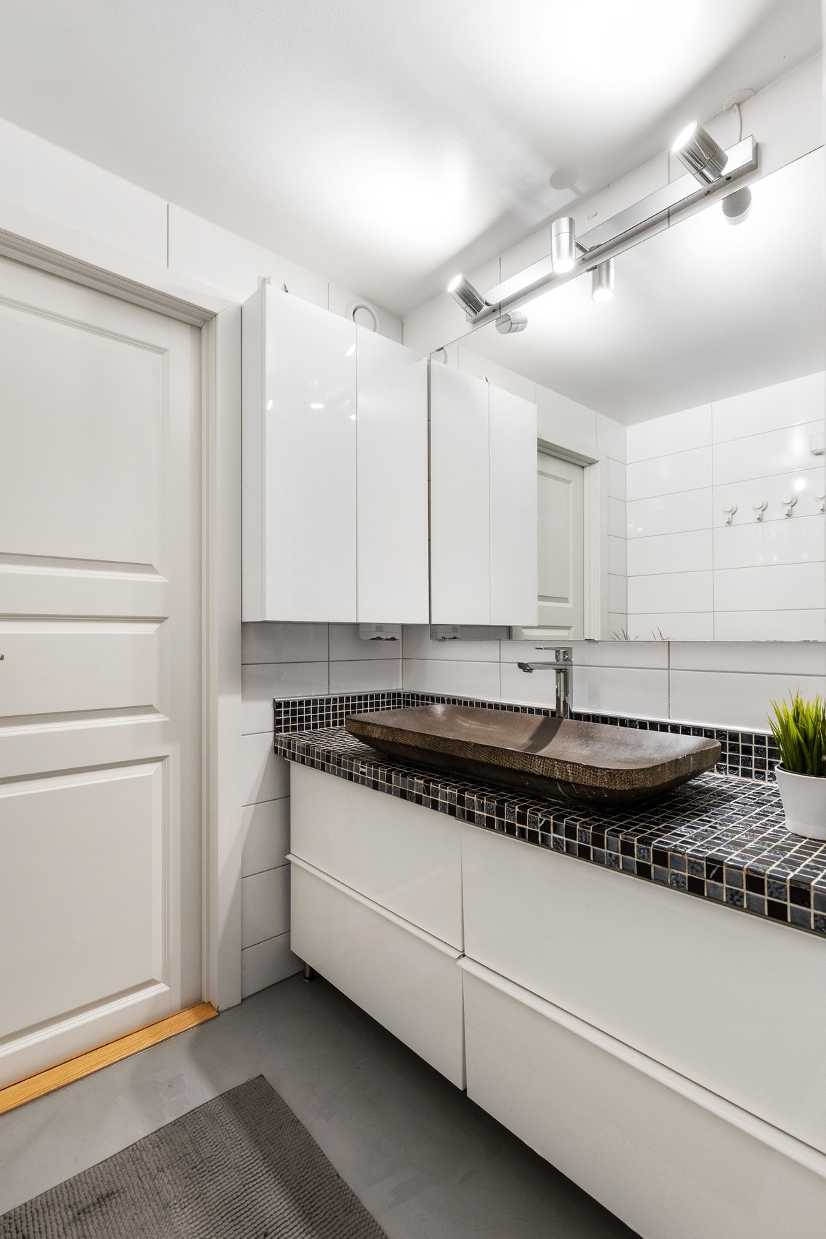 Overflatene består av gulvbelegg, flis på vegg og malte plater i taket. Galleribilde