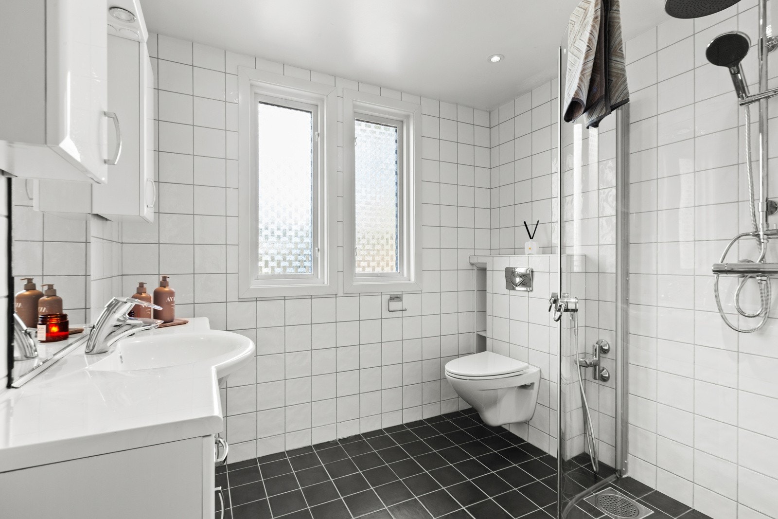 I første etasje er et romslig og lyst baderom med hvite fliser på vegger og mørke gulvfliser med gulvvarme. Badet er i følge eier pusset opp i 2008. Galleribilde