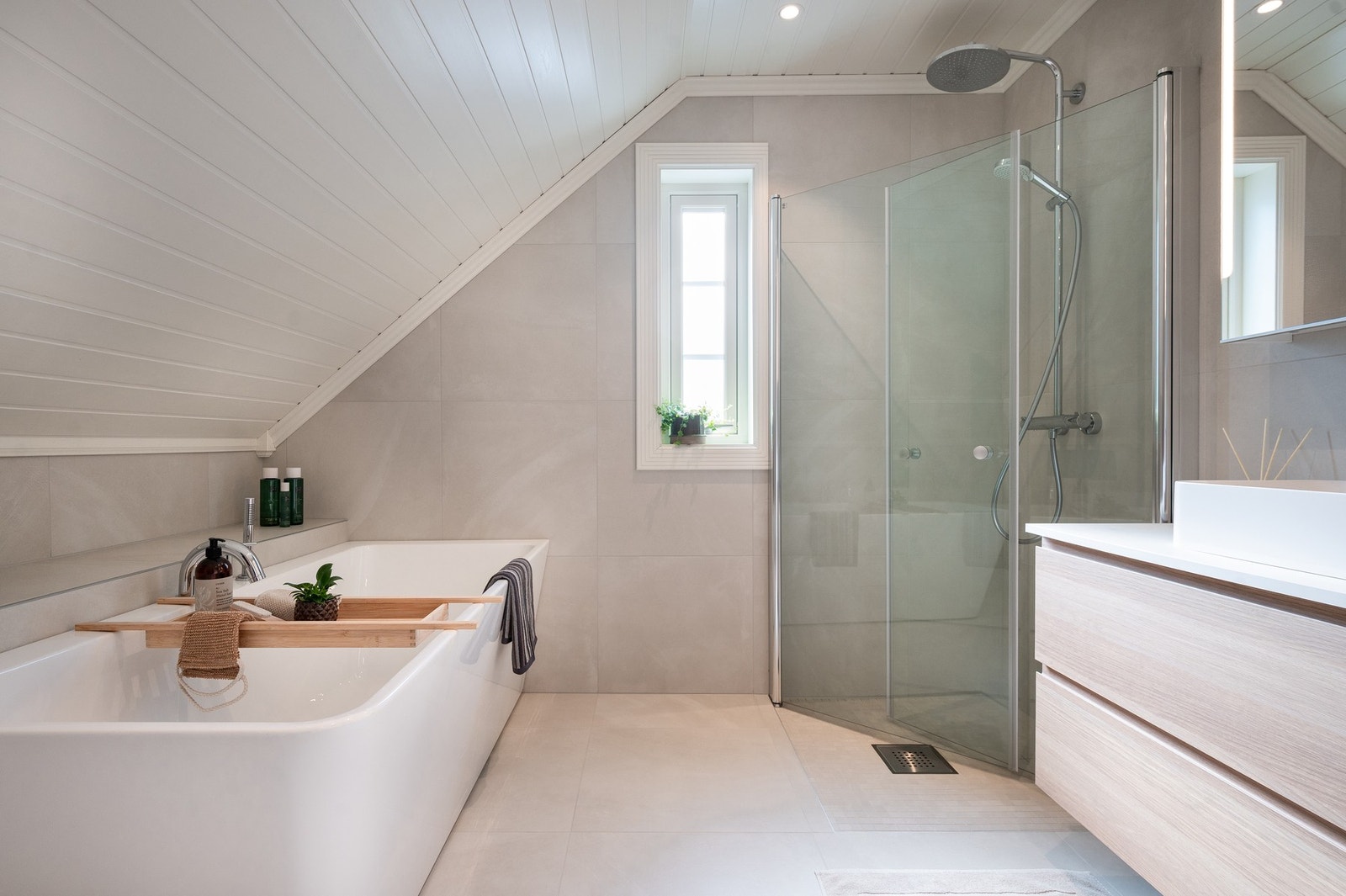 Det er innredet med speilskap, vegghengt servantinnredning, innredning, dusjhjørne, badekar og vegghengt toalett. Galleribilde