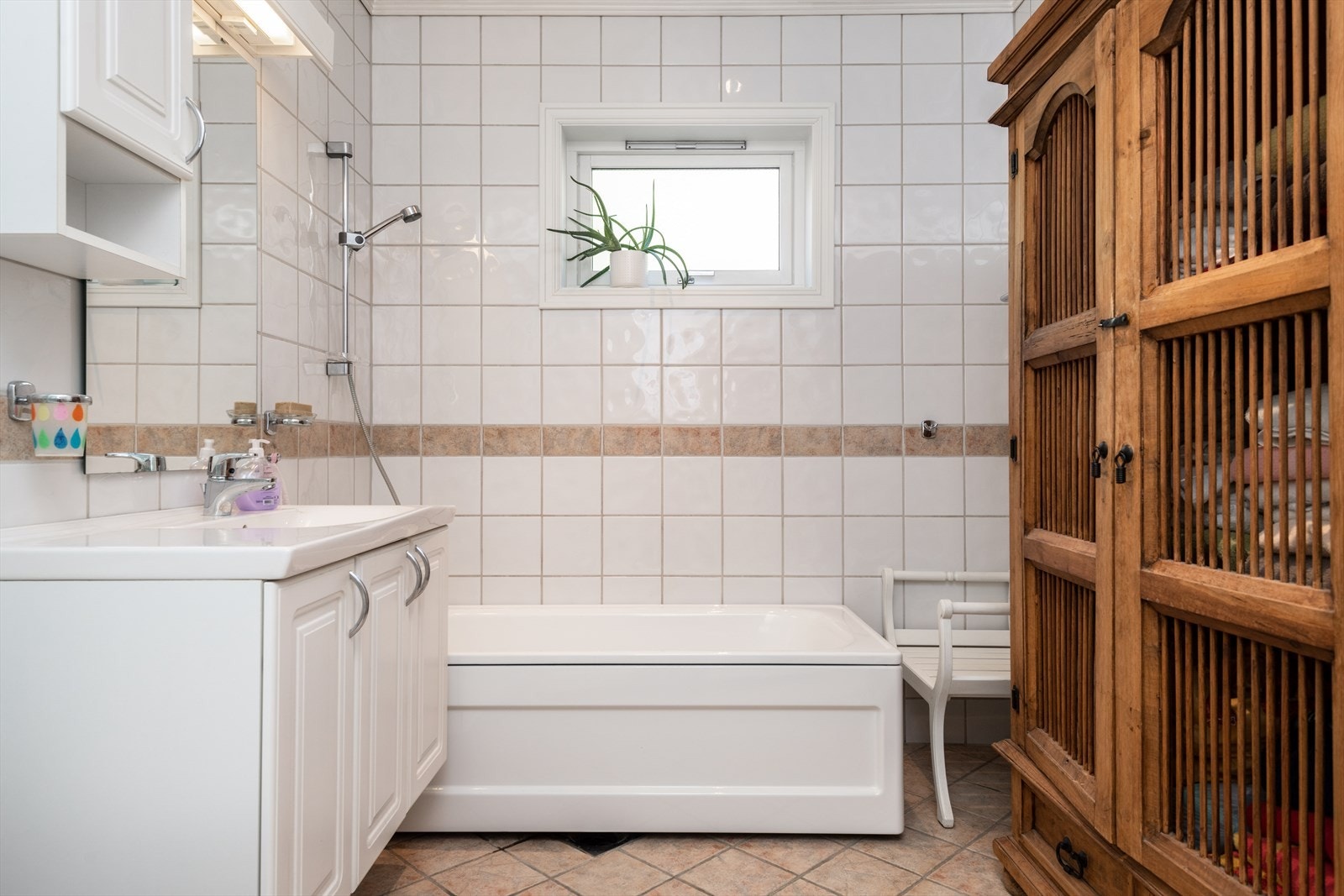 Badet er lyst og helfliset og tilbyr både dusjkabinett og badekar. Galleribilde