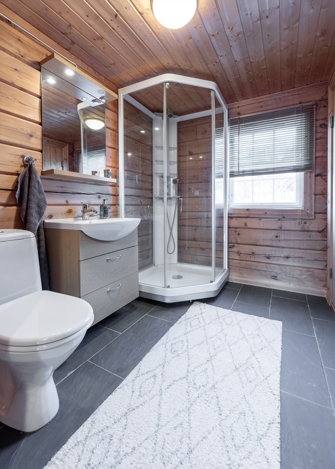 Bad med dusjkabinett og fliser på gulv. Galleribilde